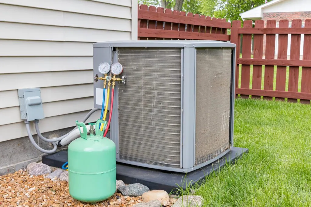 Residential HVAC unit undergoing refrigerant charge with A2L-compatible gauges and tank, illustrating air conditioning service and compliance with new low-GWP refrigerant standards in Lake County.