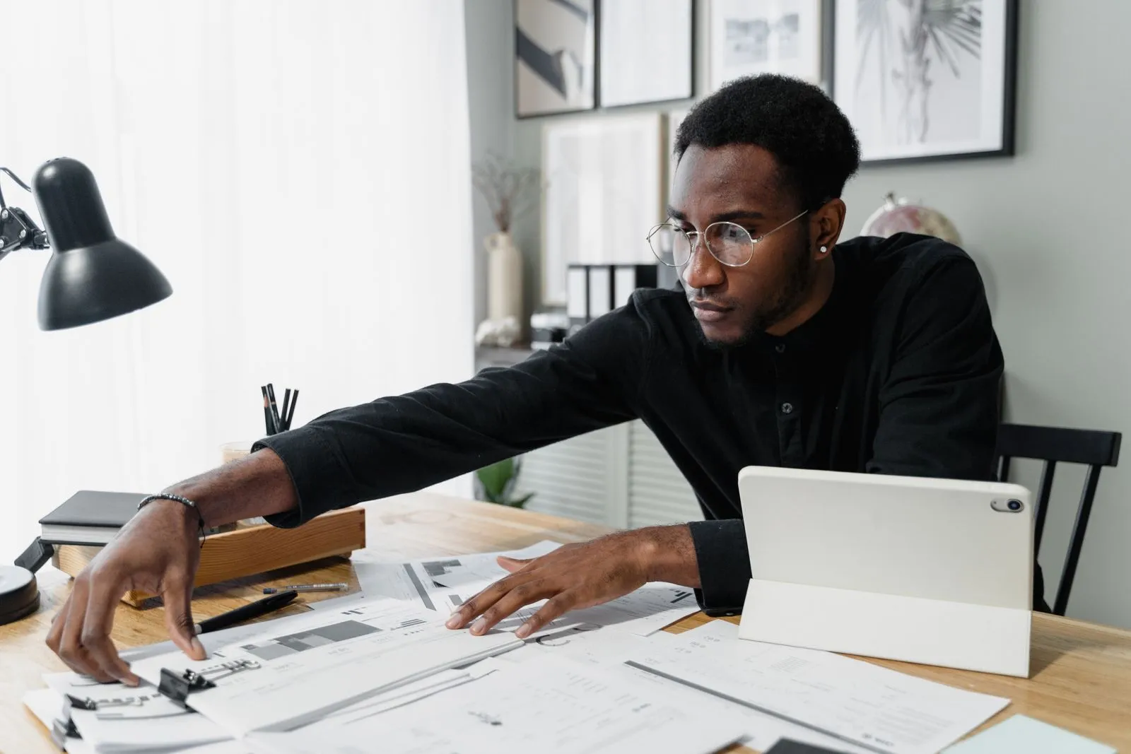 A business owner reviewing commercial HVAC budget planning documents and invoices at a desk
